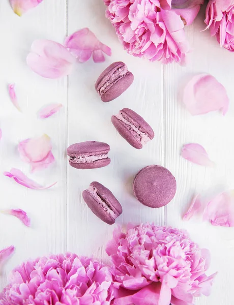 Rosa Pfingstrosenblüten Mit Macarons Auf Einem Weißen Holztisch — Stockfoto