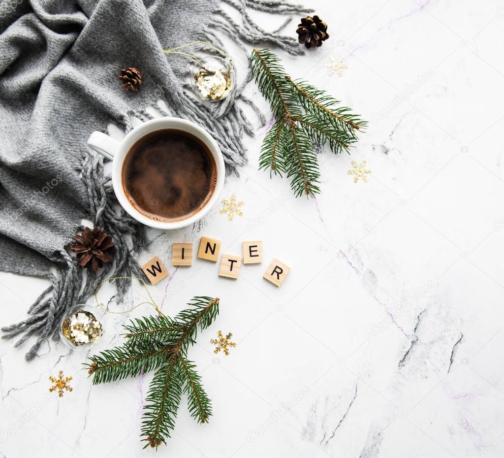 Cup of coffe, scarf and decorations on a marble background, flat lay
