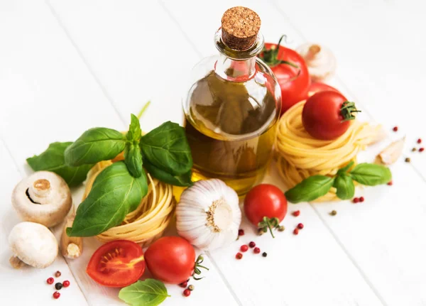 イタリア食材 オリーブ オイル スパイス パスタ トマト白木製テーブルの上 — ストック写真