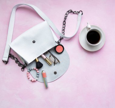 Kozmetik pembe bir beton zemin üzerine beyaz deri çanta