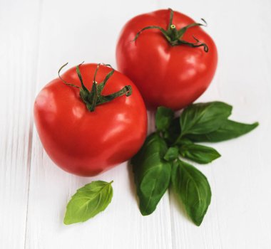 Beyaz ahşap zemin üzerinde domates ve Yeşil fesleğen