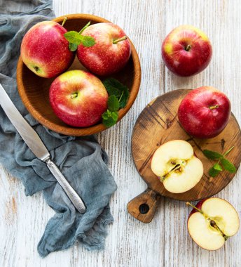 Eski ahşap bir masa üzerinde kırmızı elma ile kase