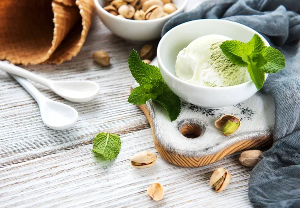 pistachio ice cream and mint with pistachio nuts on a wooden background