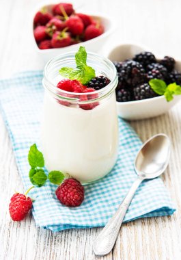 Eski ahşap bir masa üzerinde taze ahududu ile yoğurt