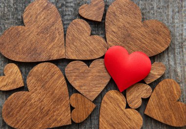 Ahşap kalp arka plan üzerinde bir kırmızı ipek kalp