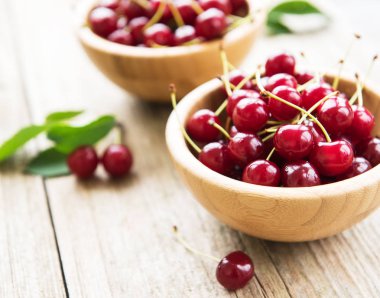 Eski ahşap bir masa üzerinde kiraz ile kase