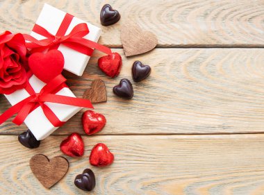 Sevgililer günü romantik arka plan - çikolata şeker, hediye kutuları ve ahşap arka plan üzerinde dekoratif kalpler