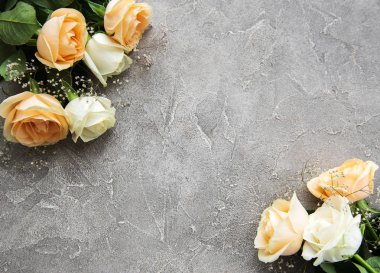 Gri taş zemin üzerine sarı ve beyaz güller