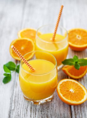 Suyu ve turuncu meyve ahşap bir masa üzerinde bardak