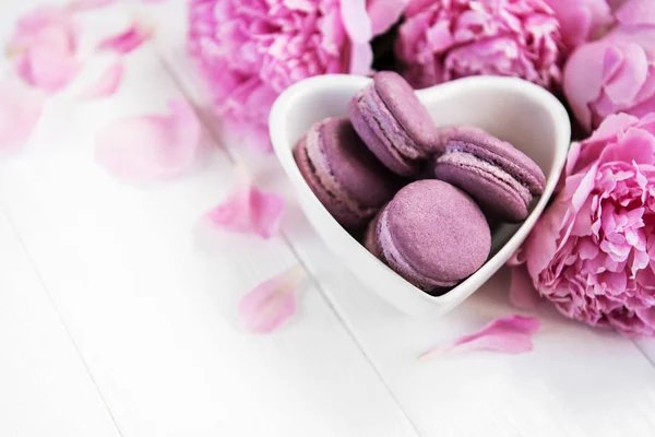 Rosa Pfingstrosenblüten Mit Macarons Auf Einem Weißen Holztisch — Stockfoto