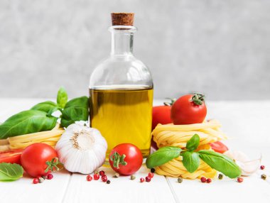 İtalyan gıda katkı maddeleri, zeytinyağı, baharat, makarna ve domates Beyaz ahşap bir masa üzerinde