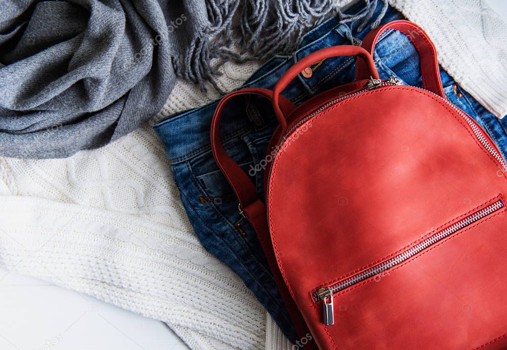 Red leather backpack and womens clothing, jeans and sweater