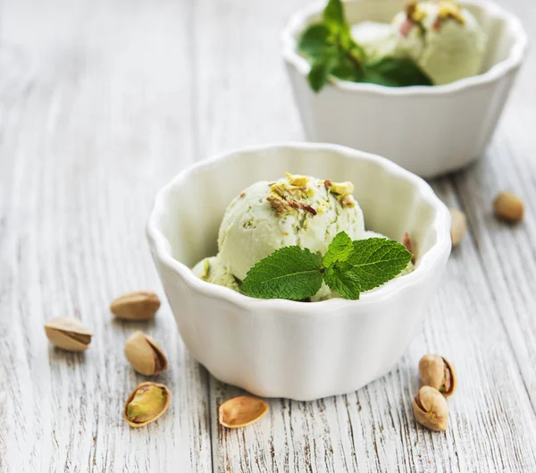 pistachio ice cream and mint with pistachio nuts on a old wooden background