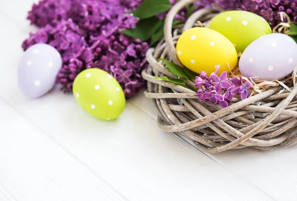 イースターの卵と春のライラックの花巣 — ストック写真