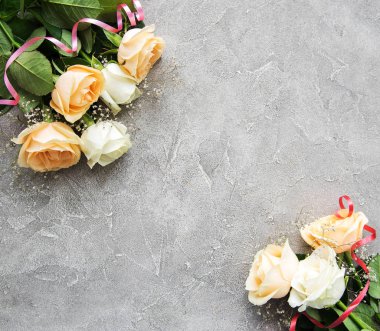 Gri taş zemin üzerine sarı ve beyaz güller