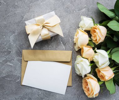 Beyaz güller ve beton zemin üzerine tebrik kartı