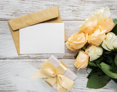 Beyaz güller ve eski ahşap bir masa üzerinde tebrik kartı