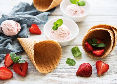 Çilekli dondurma ve waffle koni ahşap arka plan üzerinde