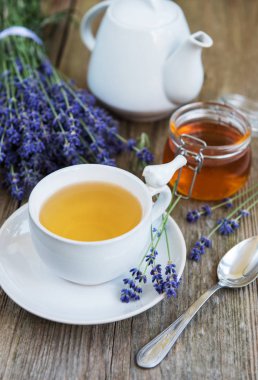 Fincan çay ve bal ile eski bir ahşap masaya lavanta çiçek