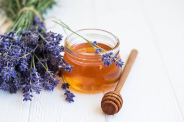 Bal ve bir beyaz tahta masaya taze lavanta çiçek ile jar