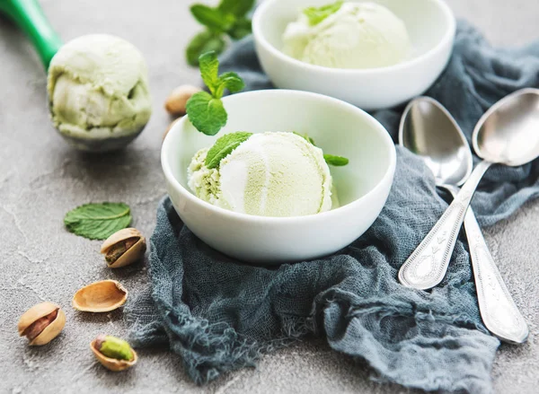 pistachio ice cream and mint with pistachio nuts on a stone background