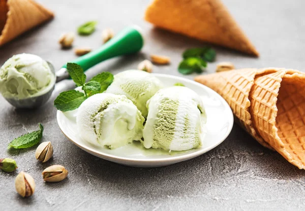 pistachio ice cream and mint with pistachio nuts on a stone background
