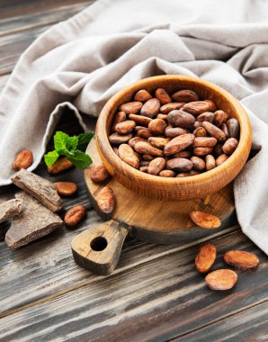 Doğal kakao çekirdekleri ve çikolata ahşap arka plan üzerinde