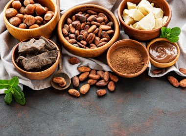 Doğal kakao tozu, tereyağı, çikolata ve kakao fasulye siyah bir zemin üzerine