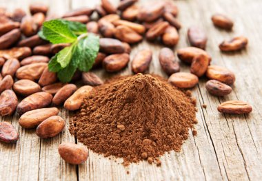 Doğal toz kakao ve kakao çekirdeği eski ahşap arka plan üzerinde