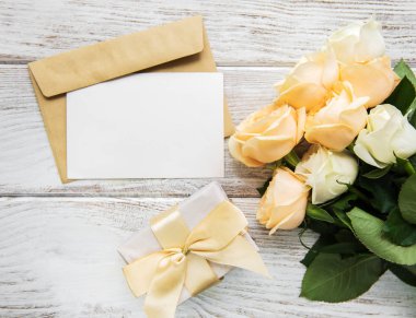 Beyaz güller ve eski ahşap bir masa üzerinde tebrik kartı