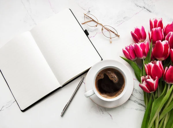 Cuaderno, taza de café y tulipanes rosados — Foto de Stock