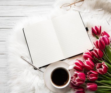 Defter, fincan kahve ve pembe laleler