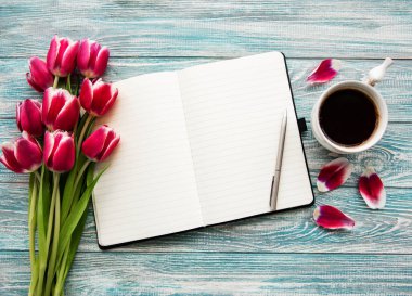 Defter, fincan kahve ve pembe laleler