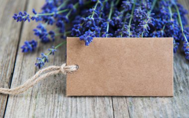 Eski ahşap bir masa üzerinde etiket ve lavanta çiçekleri boş