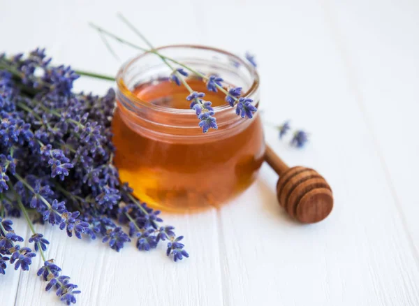 Ballı kavanoz ve taze lavanta çiçekleri.