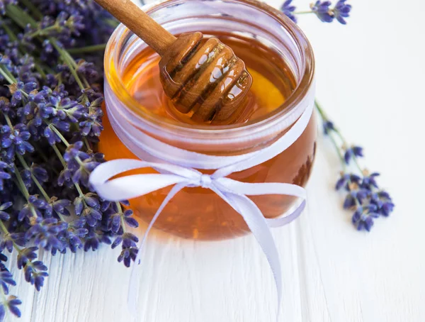 Tarro con miel y flores frescas de lavanda — Foto de Stock