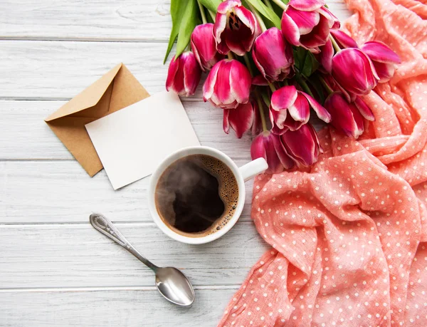 Kuppi kahvia ja vaaleanpunainen tulppaanit — kuvapankkivalokuva