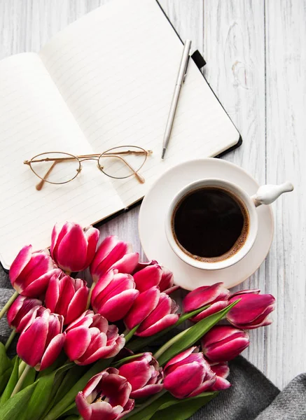 Muistikirja, kuppi kahvia ja vaaleanpunainen tulppaanit — kuvapankkivalokuva