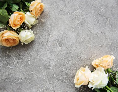 Taş bir arka planda sarı ve beyaz güller