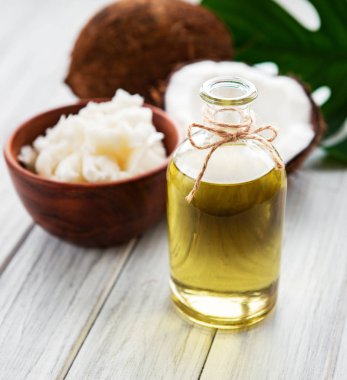 Taze hindistan cevizi yağı ve Hindistan cevizi eski ahşap bir masa üzerinde