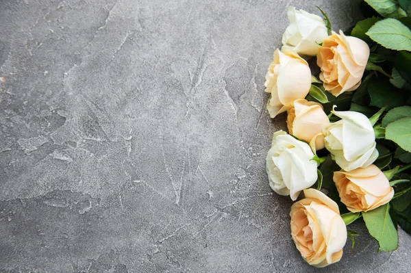 Taş bir arka planda sarı ve beyaz güller