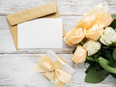 Beyaz güller ve eski ahşap bir masa üzerinde tebrik kartı