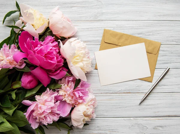 Envelop met roze pioenrozen — Stockfoto