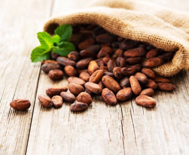 Çuval bezi çanta ahşap bir masa üzerinde ham kakao fasulye