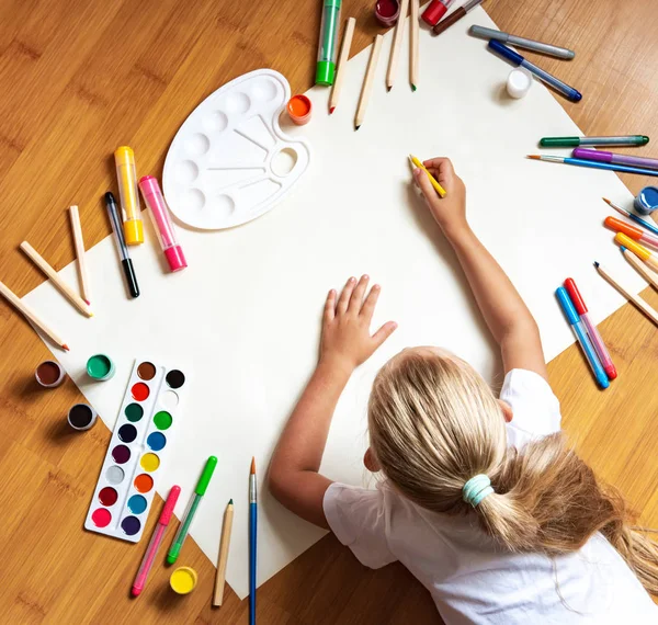 Маленька дівчинка малює в папері — стокове фото