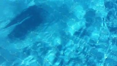 Havuzda saf mavi su ve ışık yansımaları. Yavaş çekim.