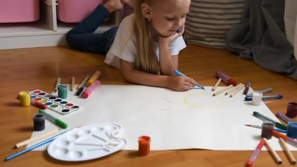 Маленькая Девочка Рисует Бумагой Полу Помещении Вид Сверху Ребенка Полу — стоковое видео