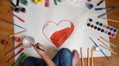 Küçük kız kapalı zemin üzerinde kağıt çizim, katta çocuğun üst görünümü