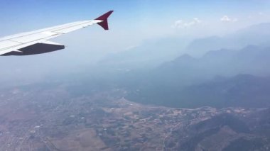 Uçak uçuşu. Bulutların üzerinde uçan bir uçağın kanadı. Uçağın penceresinden görüntüle. 