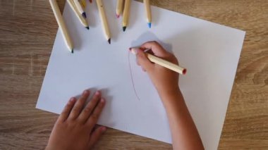 Küçük kız kapalı zemin üzerinde kağıt çizim, katta çocuğun üst görünümü